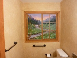 Window Mural painted on a bathroom wall. Mountainous meadow and stream on view. Mural by Ellen Leigh