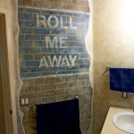 Man Cave bathroom, distressed signage on faux bricks, breakaway concrete mural by Ellen Leigh