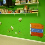 Spelling Bees. Cartoonish bees and a hive made out of books in the library at the day care. Mural by Ellen Leigh
