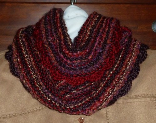 Red multicolored hand knit infinity cowl scarf. Hand knitted with hand dyed and hand spun yarn, soft acrylics, and a bit of sparkle.